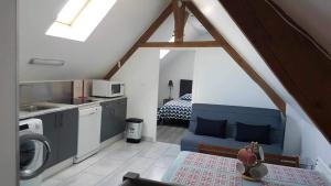 a kitchen with a blue couch in a room at JADE ET JENA in Bazicourt