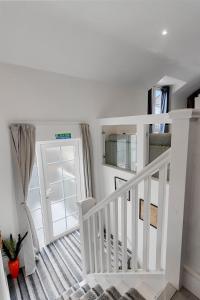 a white staircase in a room with a window at Sea views, Beachbreeze, Pet friendly, Private parking in Teignmouth