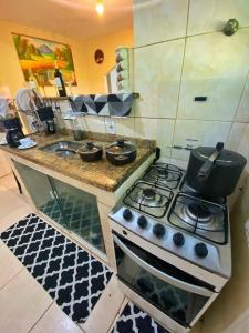 a kitchen with a stove top oven and a sink at Green House saqua in Saquarema