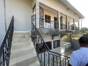 a man standing on the stairs of a building at Grand yoff 1 in Ziguinchor