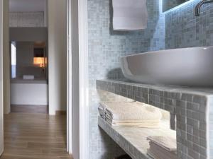 La salle de bains est pourvue d'une baignoire blanche et d'un lavabo. dans l'établissement Villa Dino, à Foce Varano