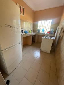 a kitchen with a refrigerator and a tile floor at Grand yoff 1 in Ziguinchor
