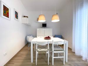 una sala da pranzo bianca con tavolo e sedie bianchi di Villa Dino a Foce Varano