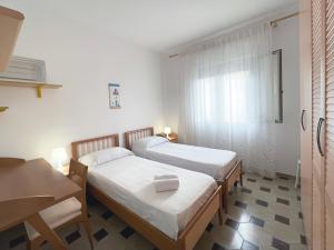 una camera con due letti, un tavolo e una finestra di Villa Dino a Foce Varano