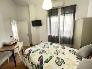 a bedroom with a bed and a desk and window at HomeStay Lopez Pando in Madrid