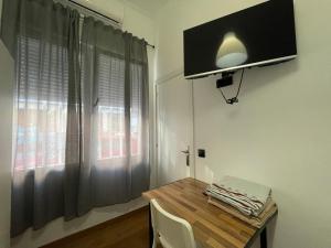 een kamer met een houten tafel en een raam bij HomeStay Lopez Pando in Madrid