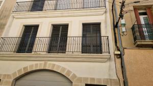 um edifício com uma porta de garagem e uma varanda em Le Malakoff em Sérignan