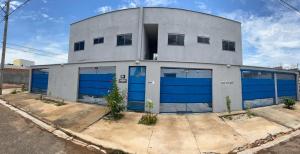 un bâtiment avec des portes de garage bleues dans une rue dans l'établissement Residencial Jasmim, à Palmas