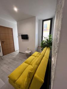 ドス・エルマーナスにあるApartamento Chic Centroのテレビ付きの客室内の黄色いソファ