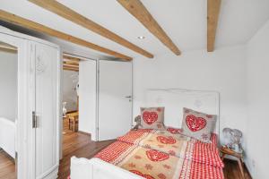 a bedroom with a bed with a red and white quilt at Kuschelige Ferienwohnung direkt an der Skipiste in Wildhaus