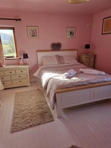 a bedroom with a bed with pink walls at Drummonds House in Sligo