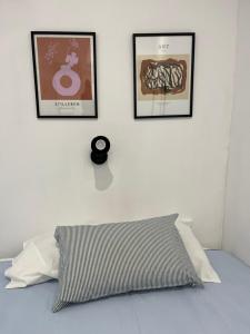 ドス・エルマーナスにあるApartamento Chic Centroの白いベッドルーム(壁に3枚の写真、枕付)