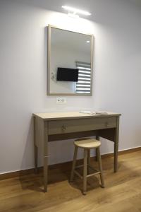 a desk with a mirror and a stool at Lythri Studios in Chios