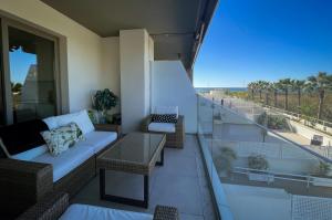 a balcony with a couch and chairs and a view of the beach at Sunny Panorama in Torrox