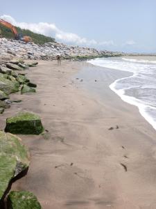 uma pessoa de pé em uma praia perto do oceano em Abuesi Beach Resort em Takoradi