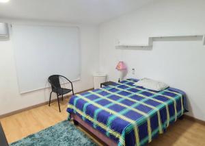 a bedroom with a bed and a chair in it at Casa campestre con las comodidades de la ciudad in Jamundí