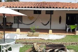 a house with a patio with a table and an umbrella at Casa campestre con las comodidades de la ciudad in Jamundí