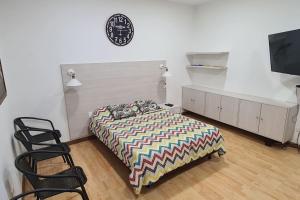 a bedroom with a bed and a tv and chairs at Casa campestre con las comodidades de la ciudad in Jamundí