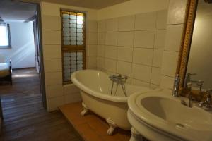 uma casa de banho com uma banheira e um lavatório em Coeur de village - maison de village - au centre - proche vignoble em Scherwiller