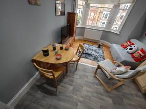 a living room with a table and a couch at LOVELY 1 BEDROOM FLAT IN FINSBURY PARK/EMIRATES STADIUM in London