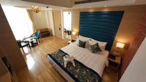 um quarto com uma cama grande e uma cabeceira azul em HOTEL SURYA GRAND em Siliguri