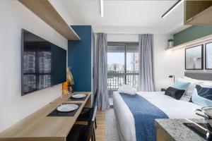 a hotel room with a bed and a desk and window at 360 My Moema in São Paulo +290 photos