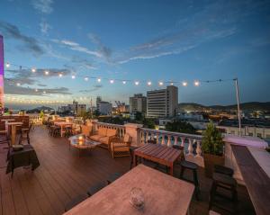 a rooftop patio with tables and chairs and a city skyline at Basilica Hotel in Santa Marta