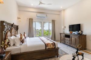 a bedroom with a large bed and a television at Hotel The Royal Courtyard in Udaipur +45 photos