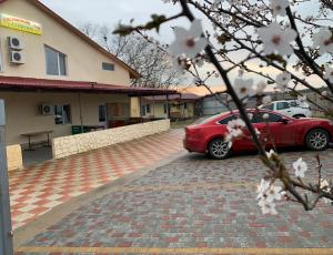 un coche rojo estacionado frente a un edificio en Гостиный Дом Comfort, en Reni