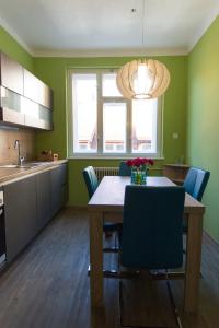 cocina con mesa de madera y sillas azules en Cozy apartment in heart of Maribor / big terrace en Maribor