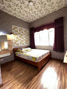 1 dormitorio con 1 cama en una habitación con ventana en The Habitat en Thuan An