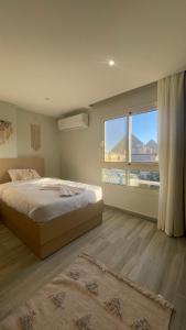 a bedroom with a bed and a large window at Diyar Pyramids Inn in Cairo