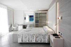 a white bedroom with a bed and a table at Grande Albergo Marin in Lignano Sabbiadoro +23 photos