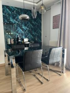 une salle à manger avec une table et des chaises en verre dans l'établissement O'Rits Paris - Magnifique appartement proche Paris, à Rueil-Malmaison