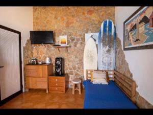 a room with a bed and a surfboard on the wall at 2 bedrooms house at Aljezur 100 m away from the beach with sea view furnished terrace and wifi in Aljezur