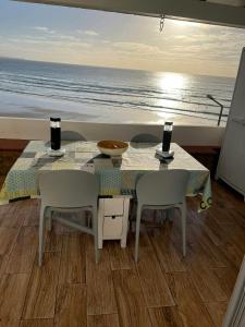 a table and chairs with a view of the ocean at 2 bedrooms house at Aljezur 100 m away from the beach with sea view furnished terrace and wifi in Aljezur