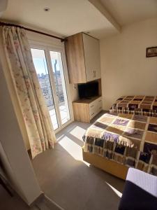 a bedroom with two beds and a large window at Villa Sotiri in Sarandë
