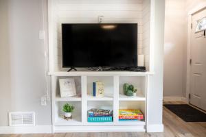 a white entertainment center with a flat screen tv at Modern Boho Bungalow - Near MOA in Saint Paul