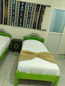 Un dormitorio con una cama verde con un arco. en Sidi Mehrez HOTEL en Túnez