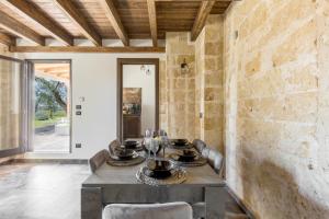 ein Esszimmer mit Steinwänden, einem Tisch und Stühlen in der Unterkunft Villetta Mora by BarbarHouse in Torre Lapillo