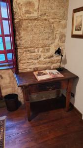 un escritorio de madera en una habitación con una pared de ladrillo en Casa Rural del General Albelda, en Villasante