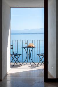 una mesa y sillas en un balcón con vistas al agua en La Casetta sul mare en Castellammare del Golfo