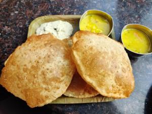 two pieces of bread on a plate with two dipping sauces at The Balcony Hotel in Hyderabad