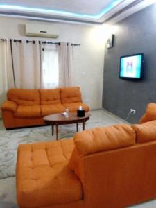 uma sala de estar com dois sofás laranja e uma mesa em EKA ELITE HOTEL em Lomé