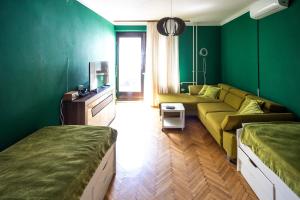 - un salon avec des murs verts et un canapé dans l'établissement Cozy apartment in heart of Maribor / big terrace, à Maribor