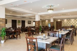a restaurant with tables and chairs in a room at Hotel The Royal Courtyard in Udaipur