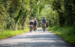 un grupo de personas montando bicicletas por un camino en Camping Colleville-sur-Mer, en Colleville-sur-Mer
