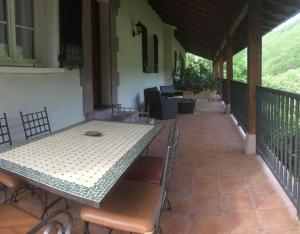 eine Terrasse mit einem Tisch und Stühlen auf einer Veranda in der Unterkunft Etxezurialde ll in Valcarlos
