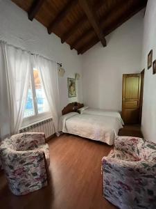 1 Schlafzimmer mit einem Bett, 2 Stühlen und einem Fenster in der Unterkunft Etxezurialde ll in Valcarlos