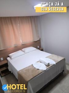 a hotel room with a bed with towels on it at Hotel Accordes in Campo Grande